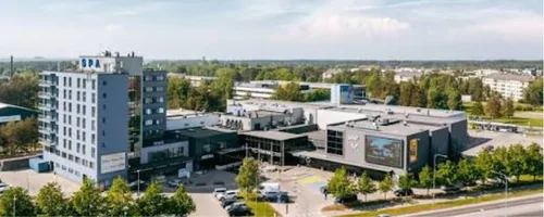 Survepesu Viimsis, SPA-kirjaga kõrghoone ja ärihooned linnulennult, tuulutatud plaatfassaadi pestakse madala survega, et vesi ei tungiks plaatide vahelt soojustuseni.